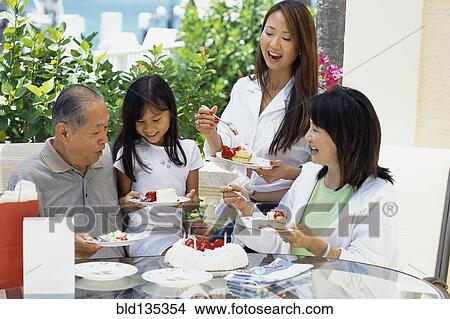 Picture - Family eating cake together at birthday. Fotosearch