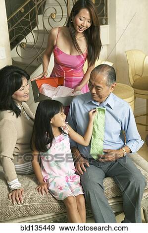 Family relaxing together in living room View Large Photo Image Stock Photo - Family relaxing together in living room. Fotosearch