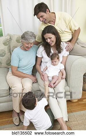 Family relaxing together on sofa View Large Photo Image Stock Image - Family relaxing together on sofa. Fotosearch