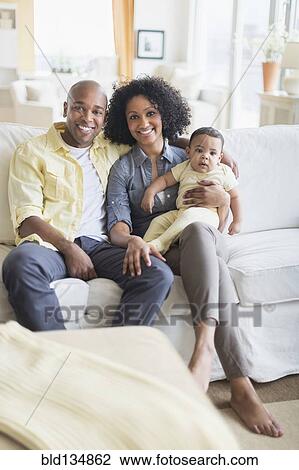 Family smiling together in living room View Large Photo Image Stock Image - Family smiling together in living room. Fotosearch