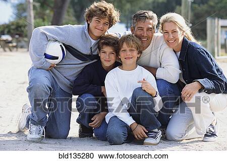 Stock Image - Family smiling together in park. Fotosearch