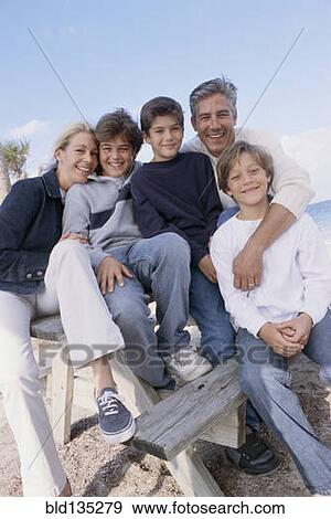 Family smiling together on picnic table View Large Photo Image Stock Photo - Family smiling together on picnic table. Fotosearch