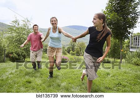 Stock Photo - Family walking together in backyard. Fotosearch