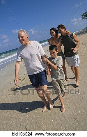 Picture - Family walking together on beach. Fotosearch