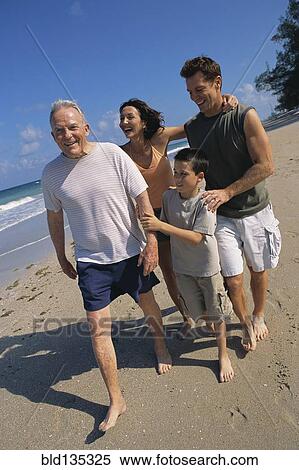 Stock Photography - Family walking together on beach. Fotosearch