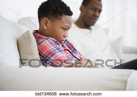 Father and son arguing on sofa View Large Photo Image Stock Photograph - Father and son arguing on sofa. Fotosearch