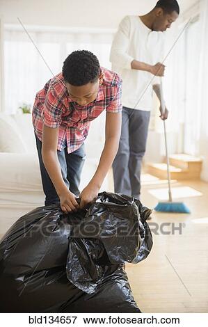 Stock Photo - Father and son doing chores in house. Fotosearch