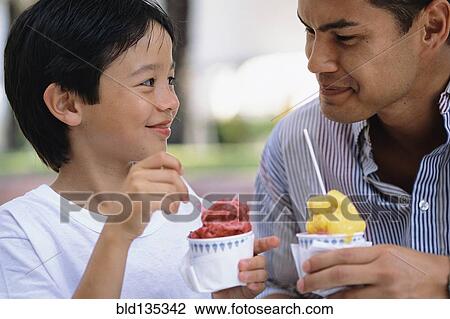 Father and son eating ice cream outdoors View Large Photo Image Stock Image - Father and son eating ice cream outdoors. Fotosearch
