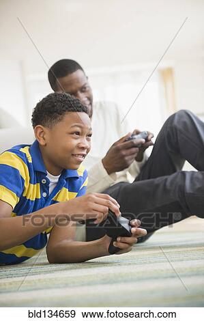 Father and son playing video games together View Large Photo Image Stock Photo - Father and son playing video games together. Fotosearch