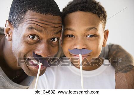 Father and son playing with fake mustaches View Large Photo Image Stock Image - Father and son playing with fake mustaches. Fotosearch