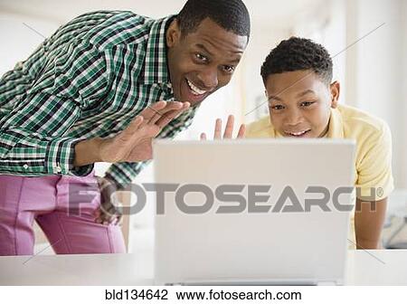 Father and son video chatting on laptop View Large Photo Image Stock Image - Father and son video chatting on laptop. Fotosearch