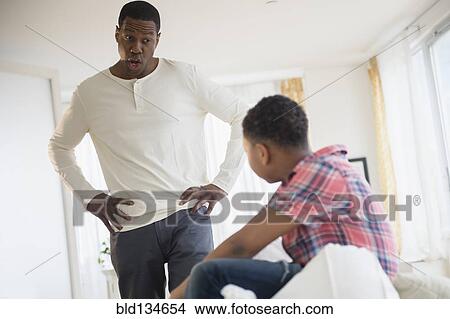 Picture - Father scolding son in bedroom. Fotosearch