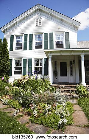 Stock Image - Flowerbeds outside suburban house. Fotosearch