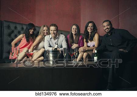 Friends smiling together in nightclub View Large Photo Image Stock Photograph - Friends smiling together in nightclub. Fotosearch