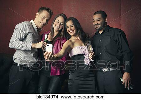 Friends taking picture together in nightclub View Large Photo Image Picture - Friends taking picture together in nightclub. Fotosearch