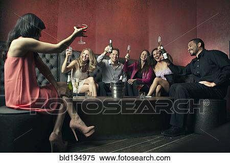 Friends toasting each other in nightclub View Large Photo Image Stock Photography - Friends toasting each other in nightclub. Fotosearch