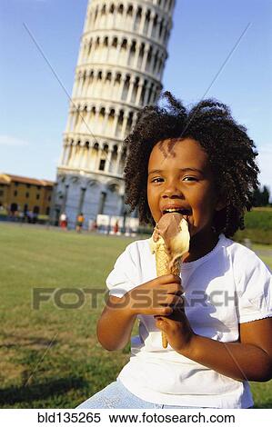 Stock Photography - Girl eating ice cream outside Leaning Tower of Pisa, Pisa, Italy. Fotosearch