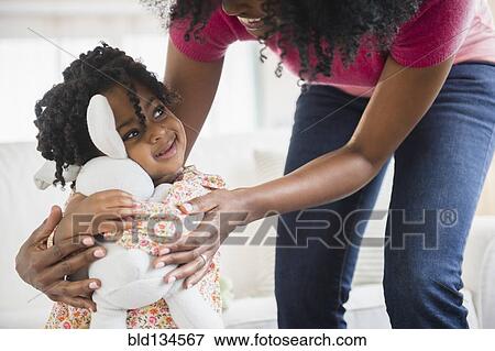Girl hugging stuffed animal View Large Photo Image Stock Photo - Girl hugging stuffed animal. Fotosearch