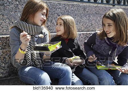 Girls eating together outdoors View Large Photo Image Stock Image - Girls eating together outdoors. Fotosearch