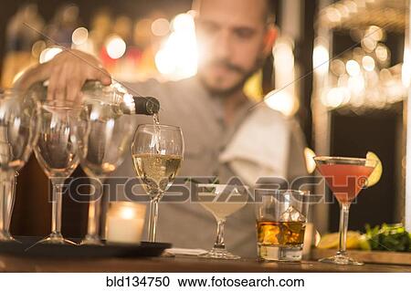 Hispanic bartender pouring drinks at bar View Large Photo Image Stock Image - Hispanic bartender pouring drinks at bar. Fotosearch