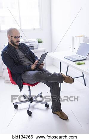 Stock Photograph - Hispanic businessman working at desk. Fotosearch