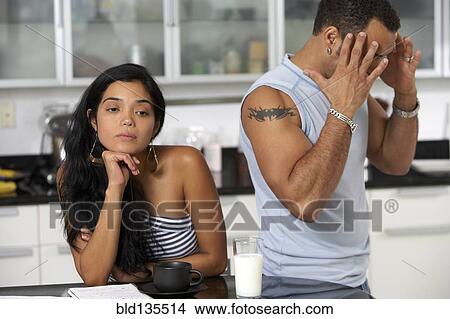 Picture - Hispanic couple arguing in kitchen. Fotosearch