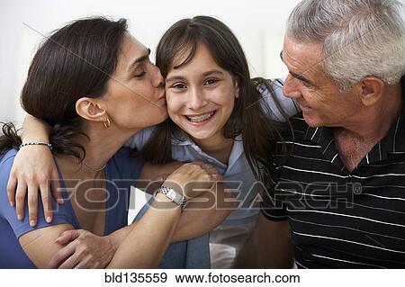 Stock Photo - Hispanic family smiling together on sofa. Fotosearch