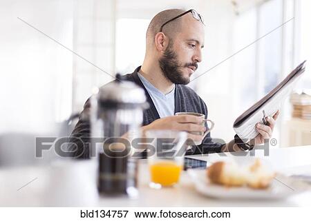 Hispanic man reading newspaper at breakfast View Large Photo Image Stock Photo - Hispanic man reading newspaper at breakfast. Fotosearch