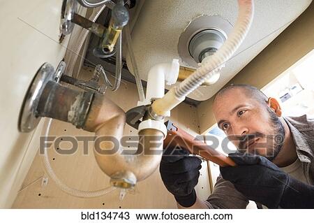 Hispanic plumber working under sink View Large Photo Image Stock Image - Hispanic plumber working under sink. Fotosearch