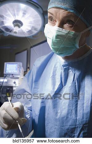 Stock Photo - Hispanic surgeon working in operating room. Fotosearch