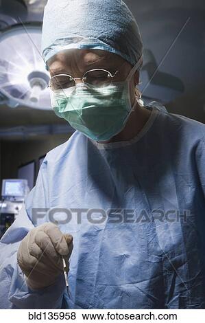 Stock Photo - Hispanic surgeon working in operating room. Fotosearch
