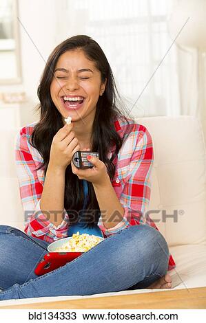 Hispanic woman eating popcorn on sofa View Large Photo Image Stock Image - Hispanic woman eating popcorn on sofa. Fotosearch