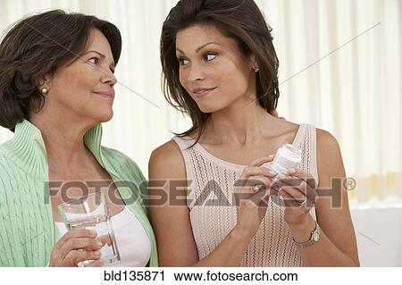 Hispanic woman giving mother medicine View Large Photo Image Stock Image - Hispanic woman giving mother medicine. Fotosearch