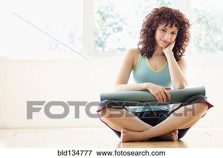 Hispanic woman holding yoga mat on floor View Large Photo Image Stock Photo - Hispanic woman holding yoga mat on floor. Fotosearch