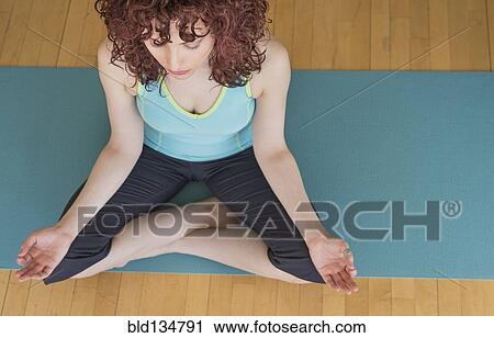 Hispanic woman meditating on yoga mat View Large Photo Image Stock Image - Hispanic woman meditating on yoga mat. Fotosearch
