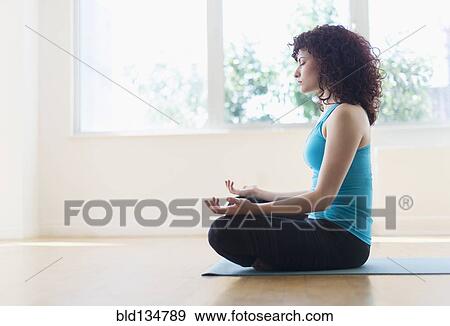 Hispanic woman meditating on yoga mat View Large Photo Image Stock Photo - Hispanic woman meditating on yoga mat. Fotosearch
