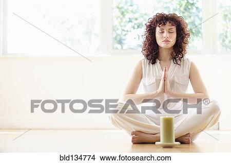Hispanic woman meditating with candle View Large Photo Image Picture - Hispanic woman meditating with candle. Fotosearch