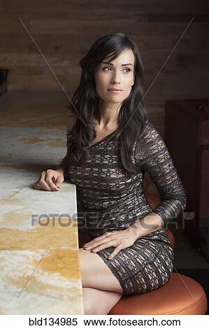 Hispanic woman sitting at bar View Large Photo Image Stock Photography - Hispanic woman sitting at bar. Fotosearch
