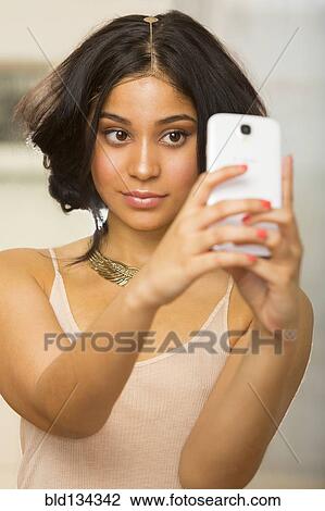 Hispanic woman taking picture of herself View Large Photo Image Stock Image - Hispanic woman taking picture of herself. Fotosearch