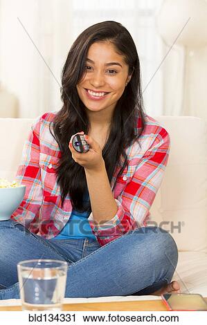 Hispanic woman watching television on sofa View Large Photo Image Stock Image - Hispanic woman watching television on sofa. Fotosearch