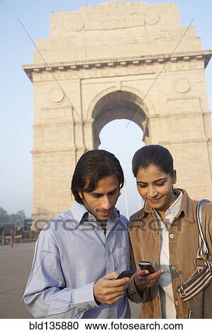 Indian couple using cell phone by India Gate, Delhi, India View Large Photo Image Stock Image - Indian couple using cell phone by India Gate, Delhi, India. Fotosearch