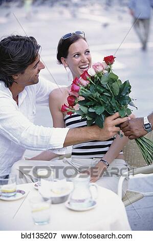Man buying flowers for girlfriend at sidewalk cafe View Large Photo Image Stock Photo - Man buying flowers for girlfriend at sidewalk cafe. Fotosearch