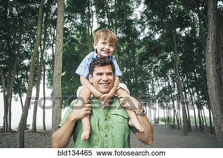 Man carrying son on wooded beach View Large Photo Image Stock Photography - Man carrying son on wooded beach. Fotosearch