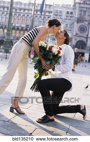 Man giving girlfriend flowers in St. Mark's Square, Venice, Veneto, Italy View Large Photo Image Stock Image - Man giving girlfriend flowers in St. Mark's Square, Venice, Veneto, Italy. Fotosearch
