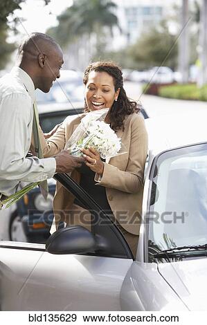 Stock Photo - Man giving girlfriend flowers. Fotosearch