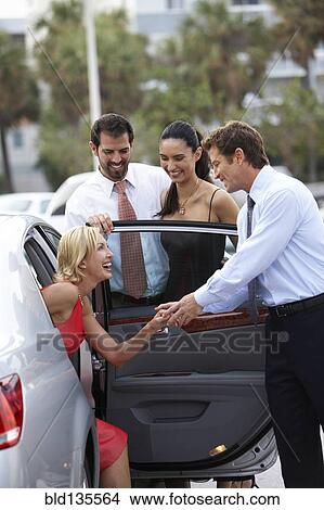Man helping girlfriend out of car View Large Photo Image Picture - Man helping girlfriend out of car. Fotosearch