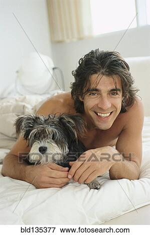 Man hugging dog on bed View Large Photo Image Stock Photo - Man hugging dog on bed. Fotosearch