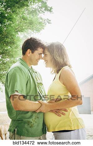Man hugging pregnant wife outdoors View Large Photo Image Stock Image - Man hugging pregnant wife outdoors. Fotosearch