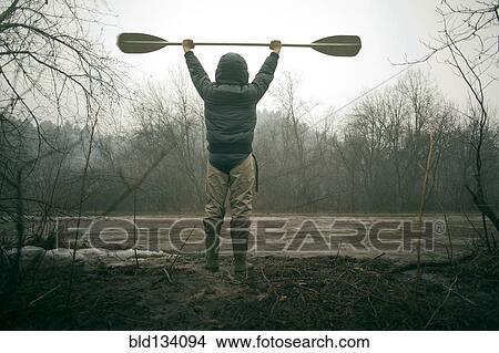 Mari man holding paddle by snowy river View Large Photo Image Picture - Mari man holding paddle by snowy river. Fotosearch