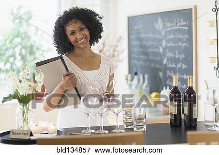 Stock Photo - Mixed race hostess smiling in restaurant. Fotosearch